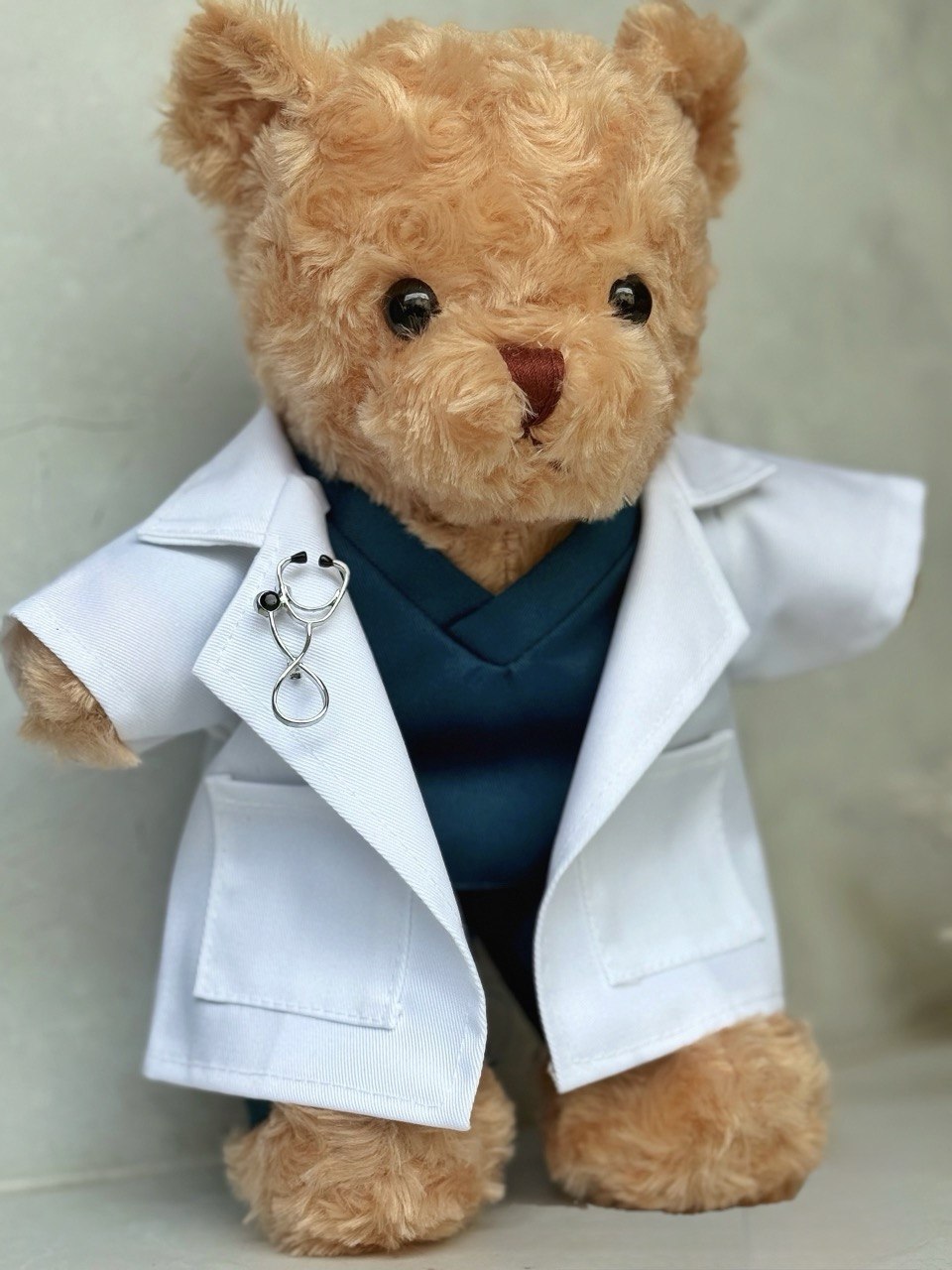 Doctor Bear — A handcrafted teddy bear in a white doctor's coat, teal scrubs, and a miniature stethoscope. Personalised with your recipient's name — the ultimate meaningful gift for a medical graduate.
